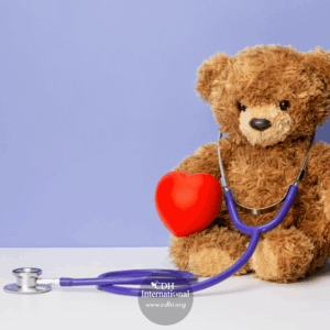 Teddy bear with a purple stethoscope and red heart, symbolizing pediatric health care on a light background.