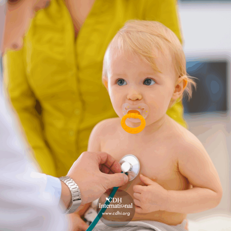 Toddler with an orange pacifier undergoes a pediatric checkup as a clinician listens with a stethoscope, caregiver in yellow nearby