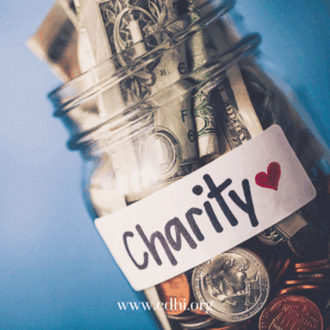 Money-filled jar with a label reading 'Charity' and a red heart, symbolizing charitable giving and donations.