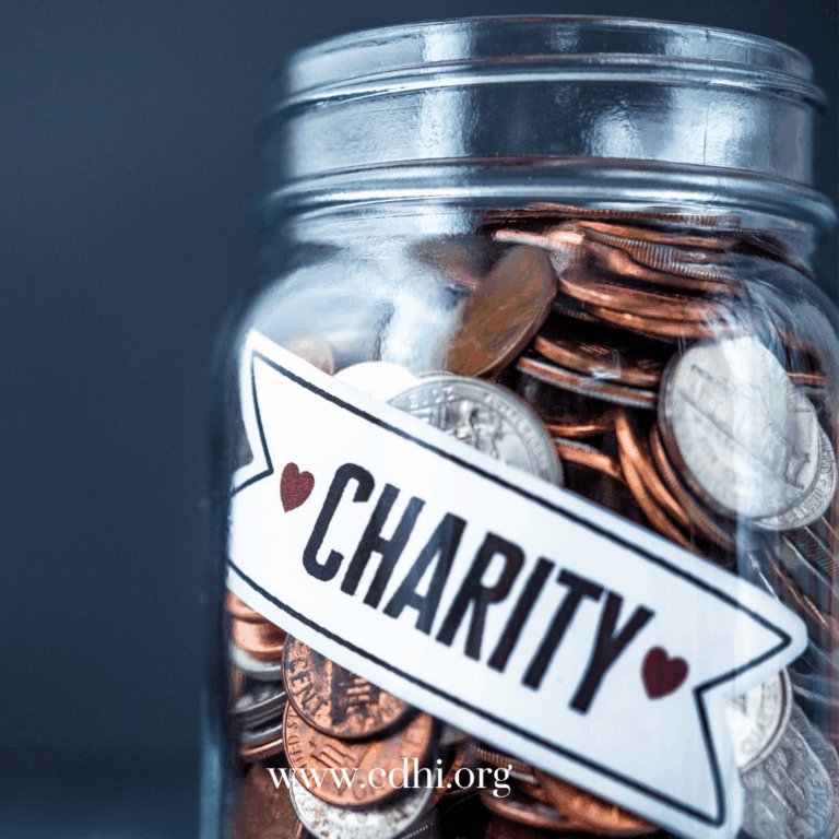Glass jar filled with coins labeled 'CHARITY' with two heart icons; donation jar for charity, website www.cdhi.org visible on label.