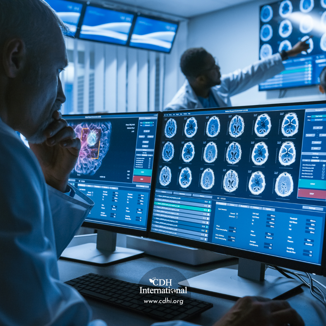 Medical professionals review multiple brain MRI scans on high‑tech monitor setup in a lab.