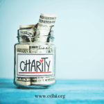 Glass jar filled with rolled dollar bills labeled Charity, with cdhi.org visible at the bottom edge.