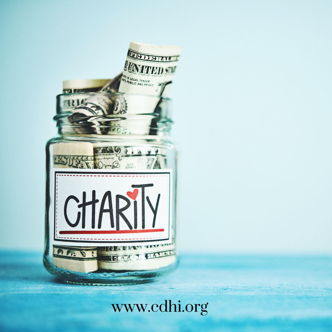Glass jar filled with rolled dollar bills labeled Charity, with cdhi.org visible at the bottom edge.
